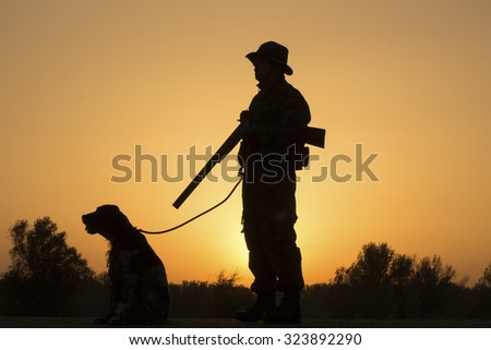 Beutiful sunset of hunter with a dog and gun