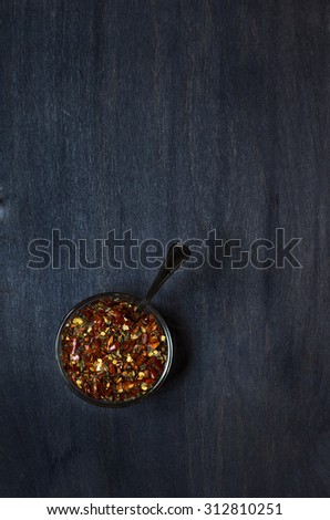 plate with condiment (pepper, garlic, basil) on dark background. Top view