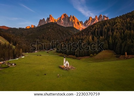 Val Di Funes, Dolomites, Italy - Aerial view of the beautiful St. Johann Church (Chiesetta di San Giovanni in Ranui) at South Tyrol with the Italian Dolomites in warm sunset colors at background  Stok fotoğraf © 