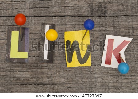 LINK made of letters from newspapers with pins on the wooden background