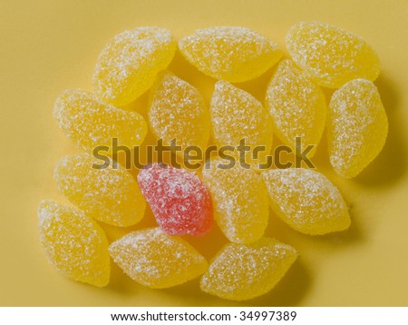 yellow candies with one red on yellow background