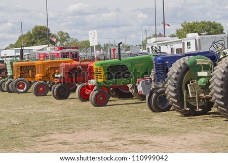 DE PERE, WI - AUGUST 18: A line of colorful vintage tractors lined up before competing at the Tractor Pull event at the Brown County Fair on August 18, 2012 in De Pere, Wisconsin.