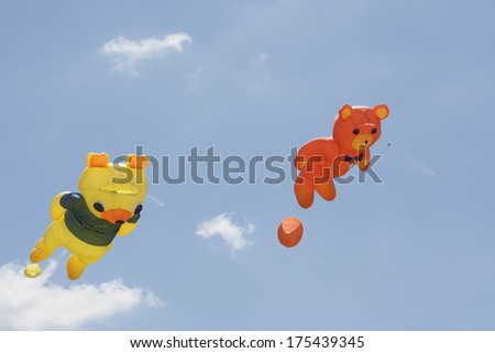 OSHKOSH, WI - JUNE 20:  An orange and yellow bear kites fly high in the sky at the Kite Festival June 20, 2009 in Oshkosh, Wisconsin.