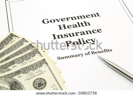 A government health insurance policy surround by hundred dollars bills and a pen.