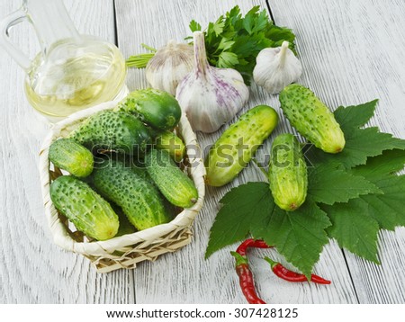 fresh cucumbers on a wooden table with herbs and garlic