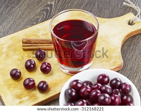 cherry juice in a glass on wooden table