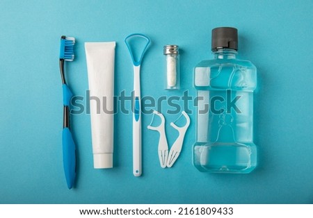 Toothbrush, tongue cleaner, floss, toothpaste tube and mouthwash on blue background with copy space. Flat lay. Dental hygiene. Oral care kit. Dentist concept. Stock foto © 