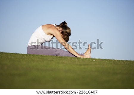 woman practicing yoga on a green lawn