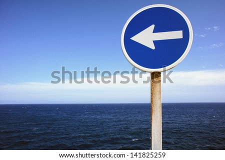 A Blue Direction Sign Indicating the Direction of Waves