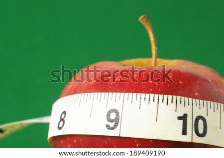 Measuring Tape Wrapped Around a Red Apple as a Symbol of Diet