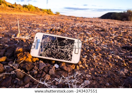 White Smartphone with Broken Display in the Desert
