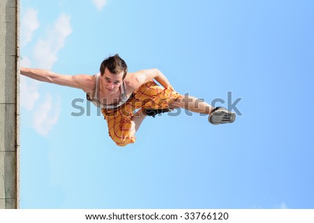 man dances a break-dance against the sky