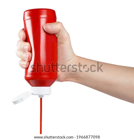 Hand squeezing ketchup out of a plastic bottle, isolated on white background Сток-фото © 