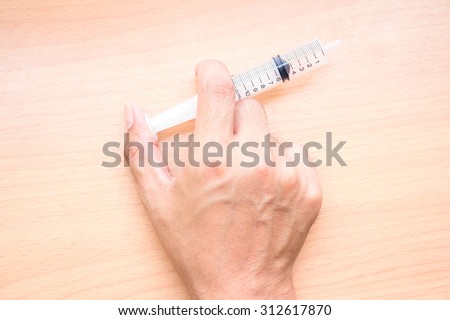 Hand of a doctor with syringe, vintage color tone.