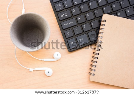 Book with headphones and the keyboard is placed on a wooden floor,vintage color tone.