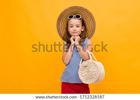 stylish glamorous beautiful girl in a straw hat and glasses on a yellow background