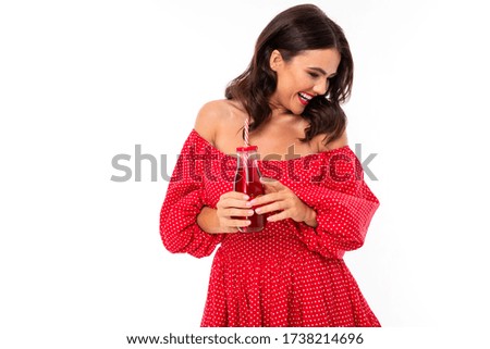 guapa morena y vestido rojo con una copa de cóctel sobre un fondo blanco