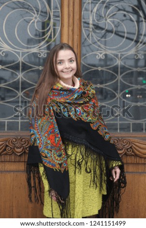 Russian tourist girl in vintage Pavlovo Posad shawl and ancient door of Pertsov's house in Moscow city, Russia. Russian folk style in architecture, fashion. Pertsov's house detail. Moscow landmark