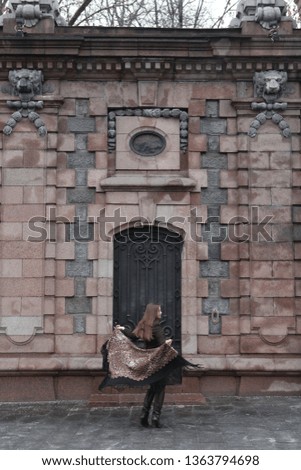 Retro style in architectural fashion. Russian girl in vintage folk Pavlovo Posad shawl with leopard print. Wooden door of building on Patriarch ponds, Moscow city, Russia. Architecture of old Moscow
