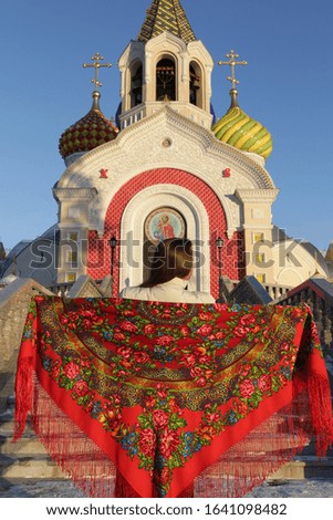 Russian tourist girl in vintage Pavlovo Posad shawl, look. Orthodox Saint Igor Chernigovsky's church in Novo-Peredelkino, Moscow city, Russia. Russian traditional national folk, retro style in fashion