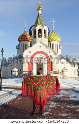 Russian tourist girl in vintage Pavlovo Posad shawl, look. Orthodox Saint Igor Chernigovsky's church in Novo-Peredelkino, Moscow city, Russia. Russian traditional national folk, retro style in fashion