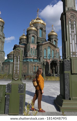 Resurrection of Christ Cathedral, main cathedral of Russian Armed Forces. Patriot Park in Moscow city, Russia. Moscow architecture landmark. Church. Tourist fashion woman with backpack. Street style