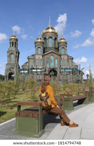 Resurrection of Christ CathedraI, main cathedral of Russian Armed Forces. Patriot Park in Moscow city, Russia. Moscow architecture landmark. Church. Tourist fashion girl with backpack. Street style