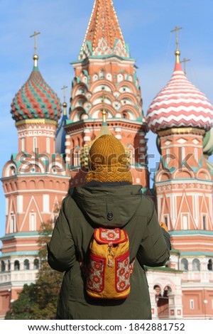 Russian tourist woman with stylish backpack on Red Square, Moscow city, Russia. Moscow landmark, monument. Moscow Kremlin, architecture. Architectural fashion. Travel, tourism in Russia. Russian style