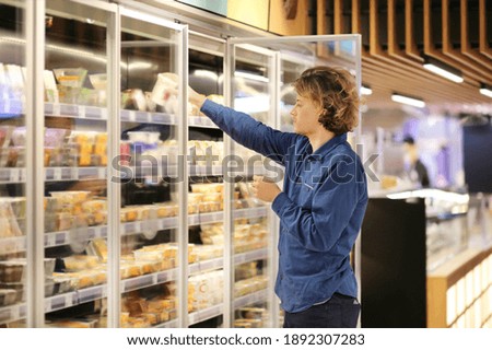 Man choosing frozen food from a supermarket freezer	
