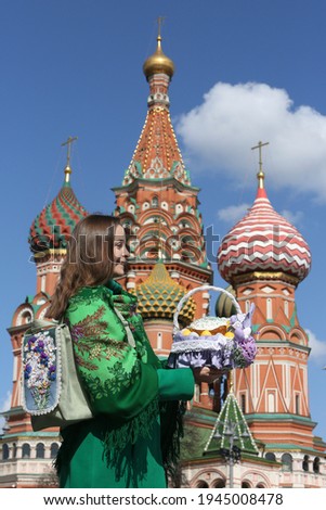 Russian woman with colorful Easter eggs, Easter cake in basket. Easter on Red Square, Moscow city, Russia. Holiday decor, Easter decoration in Russia. Russian tourist girl in Moscow Kremlin. Landmark