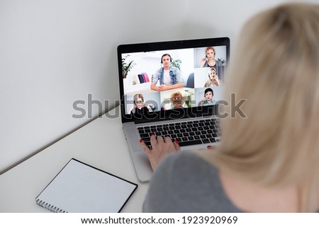 Back view of business woman talking to her colleagues about plan in video conference. business team using laptop for a online meeting in video call. Group of people smart working from home.