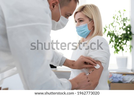 Doctor injecting vaccine to woman, covid vaccine