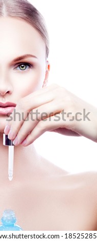 Partial beauty face of model woman with cosmetics in hand