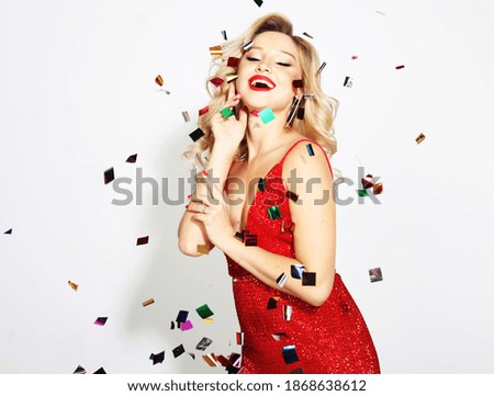 Careless, carefree, dream, holiday concept. Beautiful, attractive, pretty, charming, modern wave hairstyle lady wearing red dress with bright golden confetti over white background.