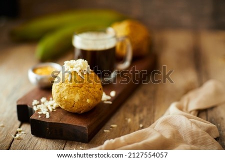 Ecuadorian bolon de verde or green plantain dumplings stuffed with cheese and accompanied by a traditional coffee. On a wooden background. Imagine de stoc © 