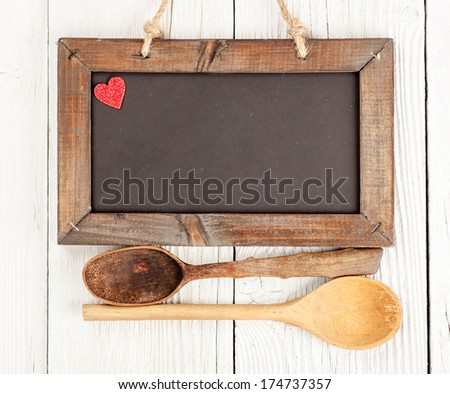 Blank chalkboard sign with wood cooking spoons and heart