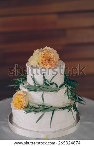 white wedding cake decorated with yellow flowers and green leaves