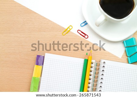 coffee mug, pencils, and a pad on a wooden table