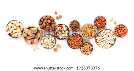 Assortment of nuts in bowls. Cashews, hazelnuts, walnuts, pistachios, pecans, pine nuts, peanuts, macadamia, almonds, brazil nuts. Food mix on white background, top view, copy space
