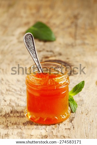 Apricot jam in a jar on the table, selective focus
