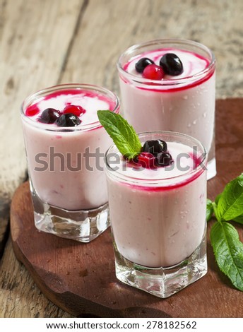 Homemade yogurt with berry juice and currants in a glass, selective focus