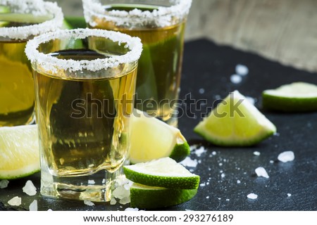 Gold Mexican tequila with lime and salt, selective focus