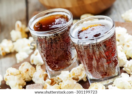 Caramel popcorn and cola in a glass, selective focus