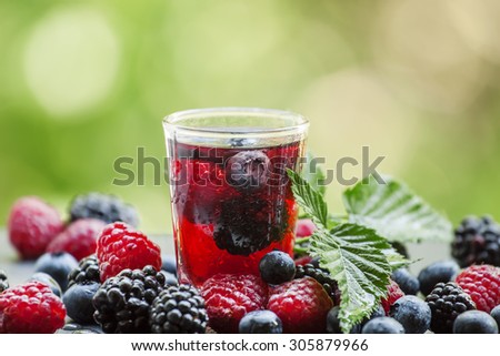 Tea with forest berries on a green natural background, selective focus