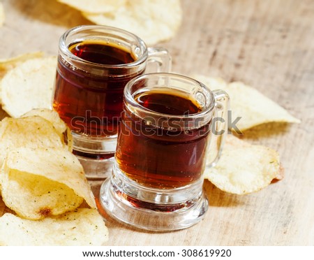 Pair of dark beer and chips, unhealthy eating concept, selective focus