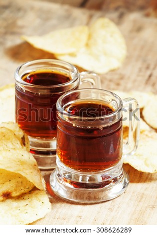 Pair of dark beer and chips, unhealthy eating concept, selective focus