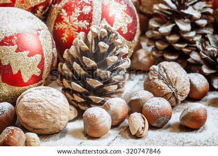 Christmas background with snow-covered fir cones, Christmas balls, nuts, selective focus