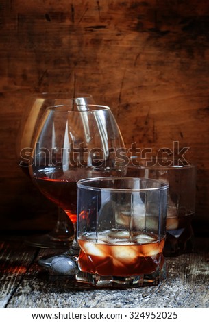 Set of hard liquor brandy, whiskey, brandy and vodka on the old wooden background, selective focus