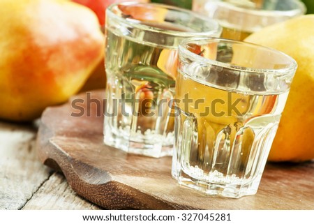 Pear fizzy drink, soda in a glass and fresh pears on a wooden background, selective focus