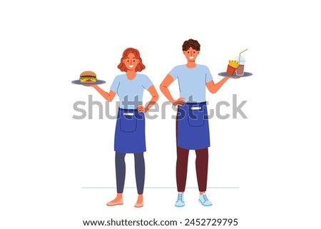 Waiters from fast food restaurant work together to deliver customers order, holding burgers and fries on trays. Man and woman working as waiters in cafe, enjoying jobs in hospitality industry